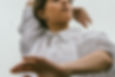 Person in a white shirt moving gently with one arm raised