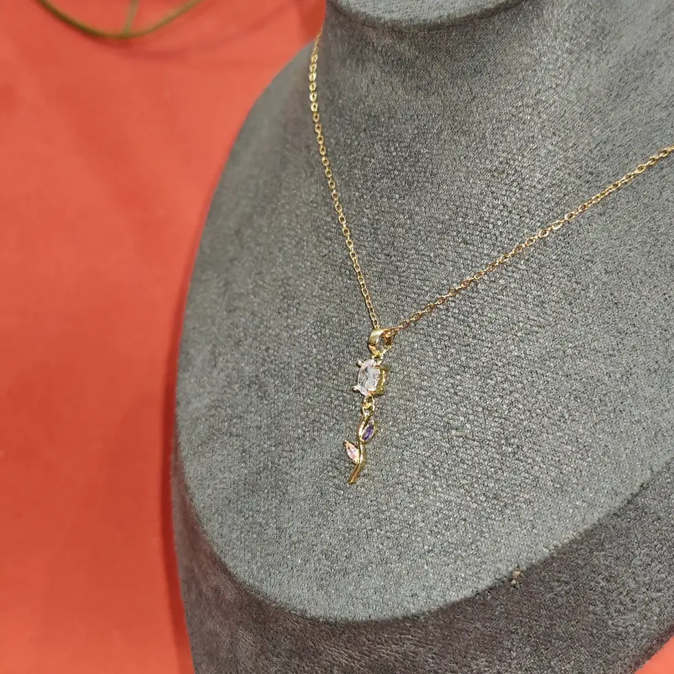 Elegant gold necklace featuring a delicate floral crystal pendant with purple marquise stone accents on a fine chain.