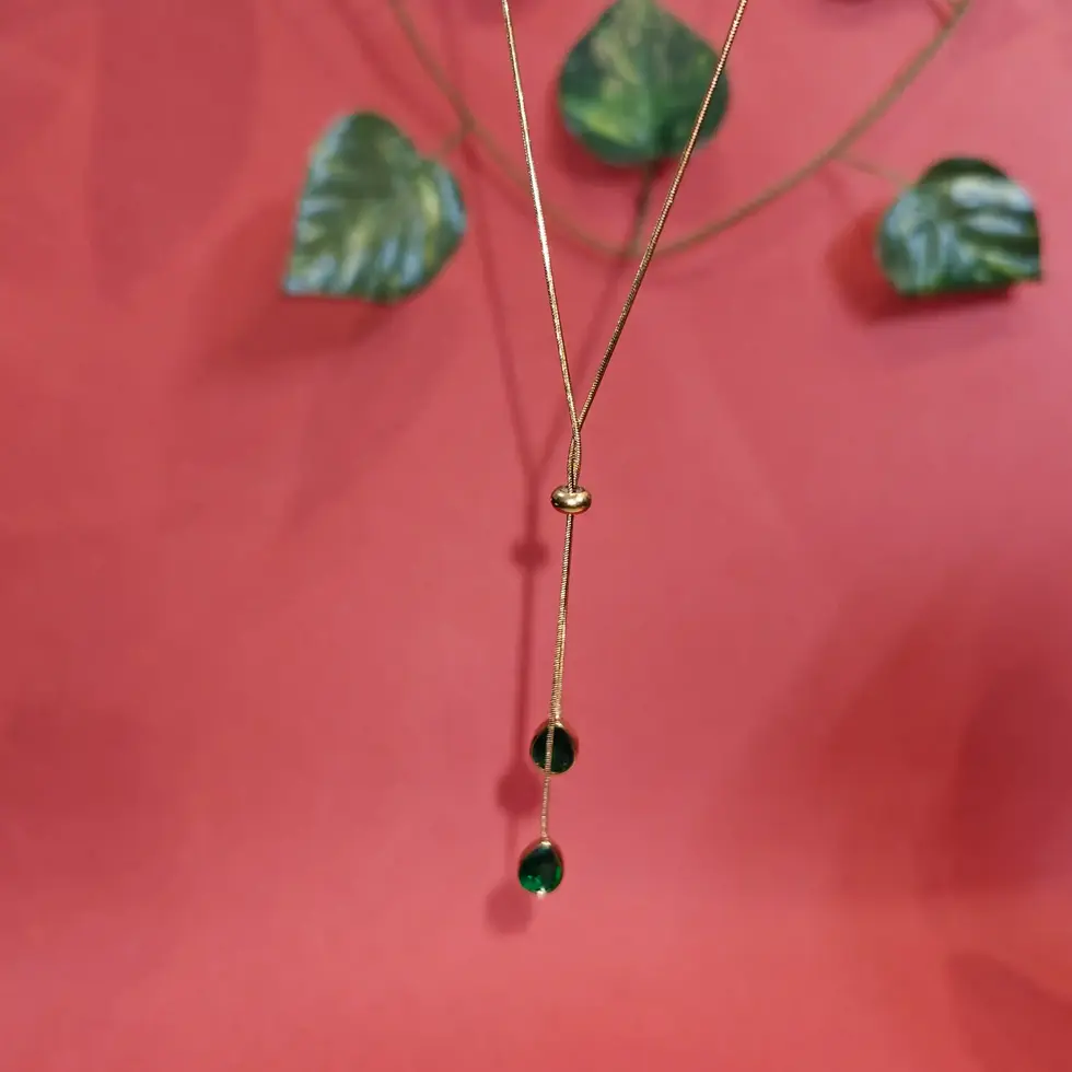 Elegant gold lariat necklace featuring two emerald green teardrop crystal pendants suspended from delicate fine chains.