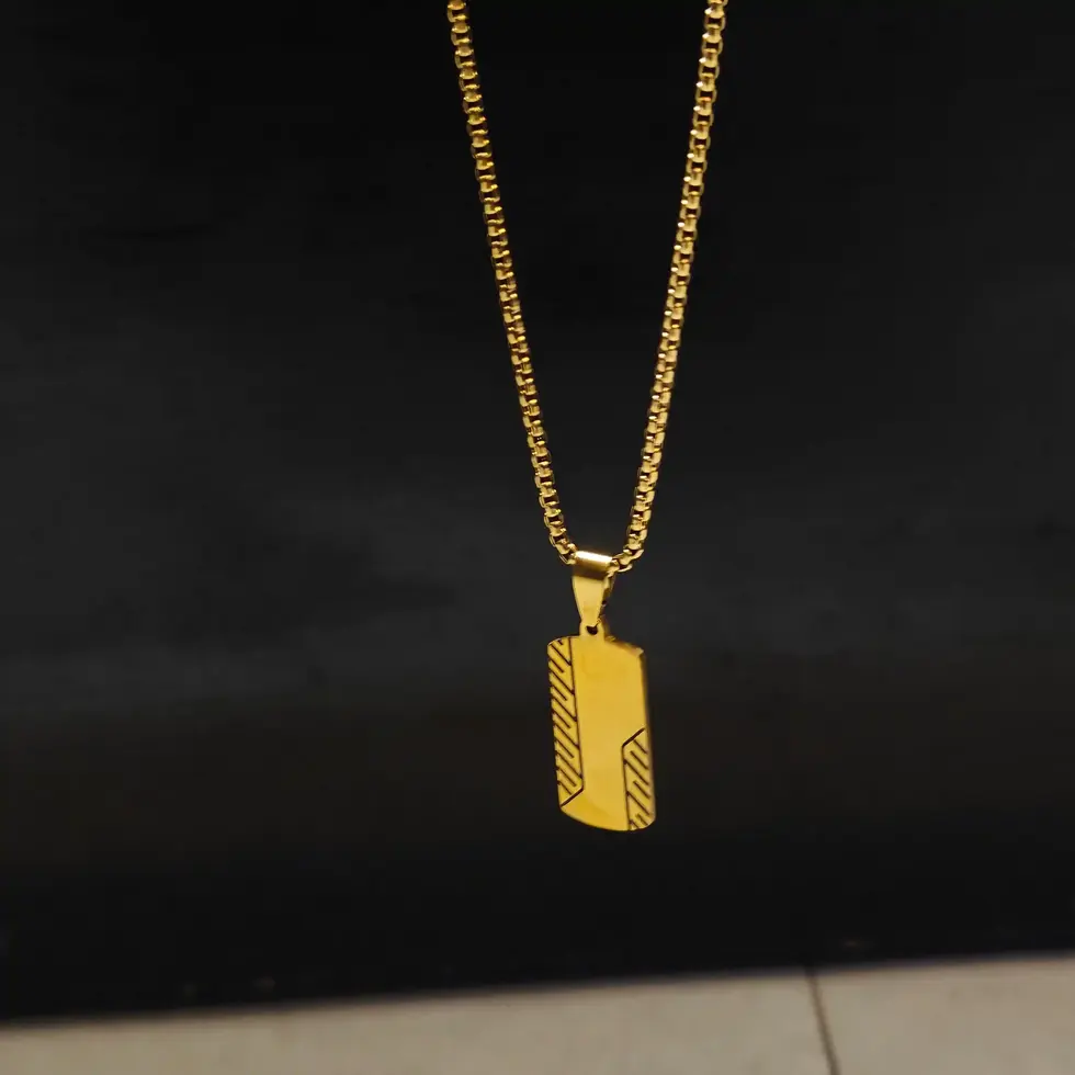 Long gold-tone men's dog tag pendant necklace featuring engraved geometric details with a sleek minimalist design.