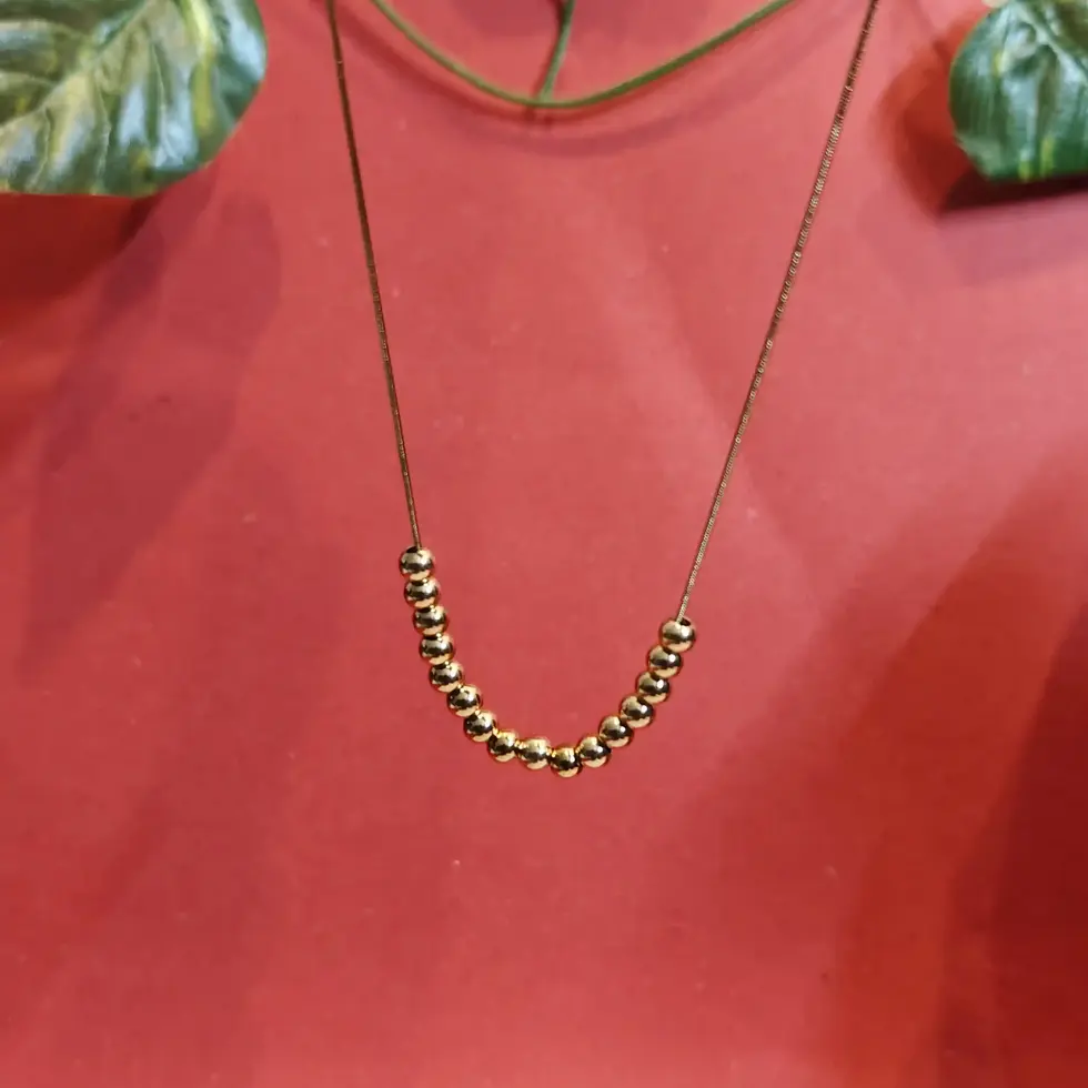 Elegant gold necklace featuring a curved arrangement of polished golden bead charms on a delicate chain.