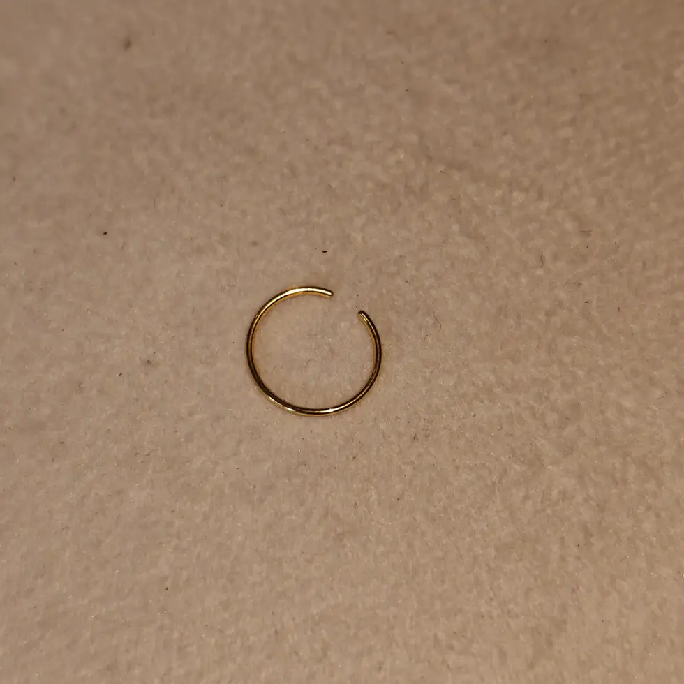 Large gold-tone non-piercing ring displayed on a neutral background. Minimal ear accessory designed for a bold everyday style