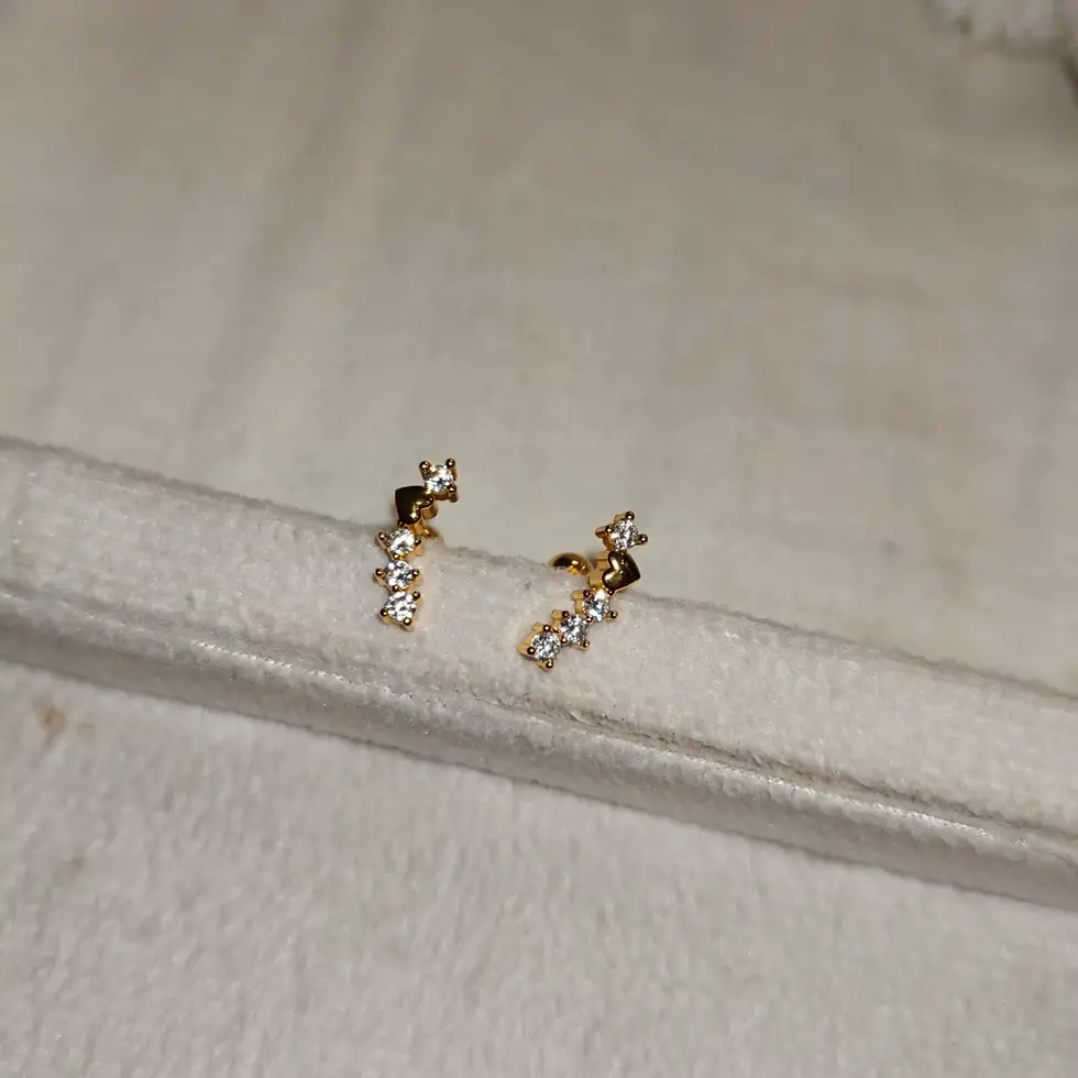 Delicate gold-plated climber stud earrings featuring a cascading arrangement of sparkling clear stones in a sleek, minimalist
