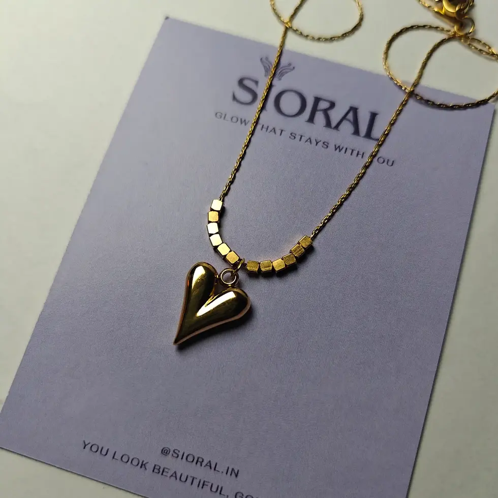 Gold-plated thin chain necklace with a heart pendant covered with tiny square-shaped beads on both sides.