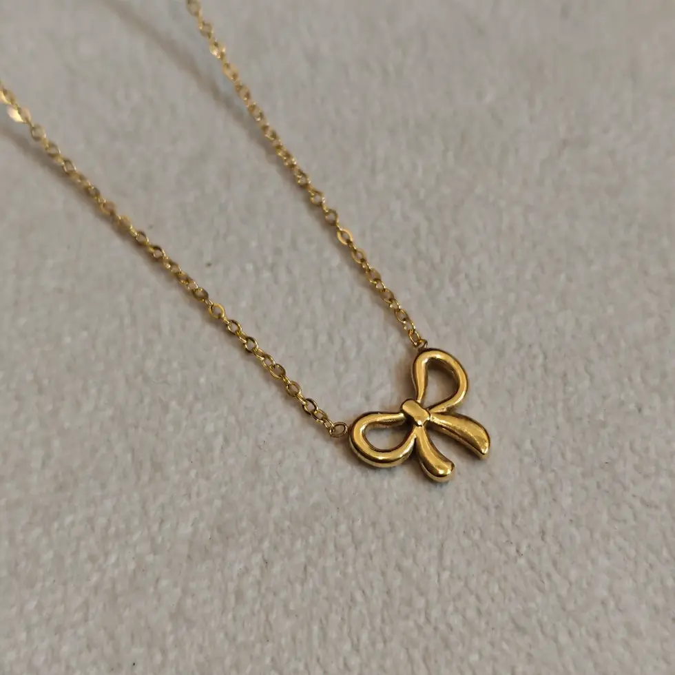 Minimal gold necklace featuring a delicate bow-shaped pendant on a fine elegant chain.
