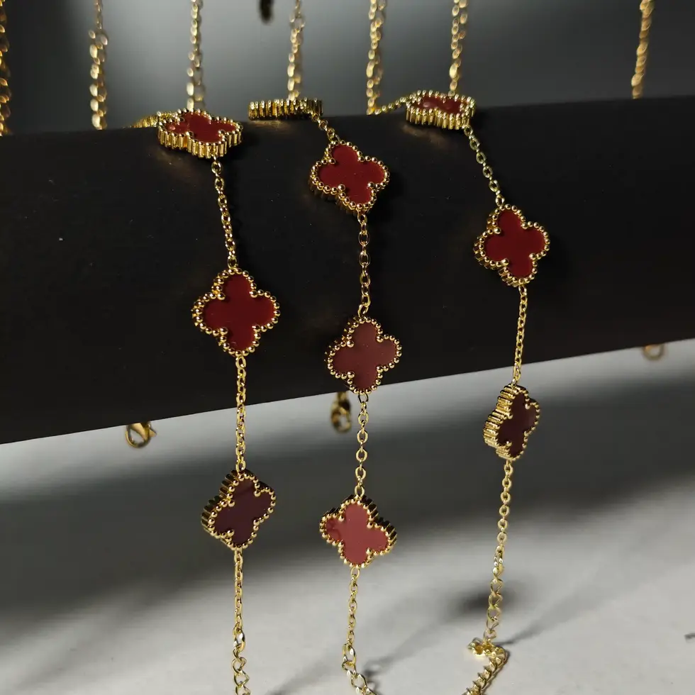 Minimal bracelet featuring a cherry red four-leaf clover charm