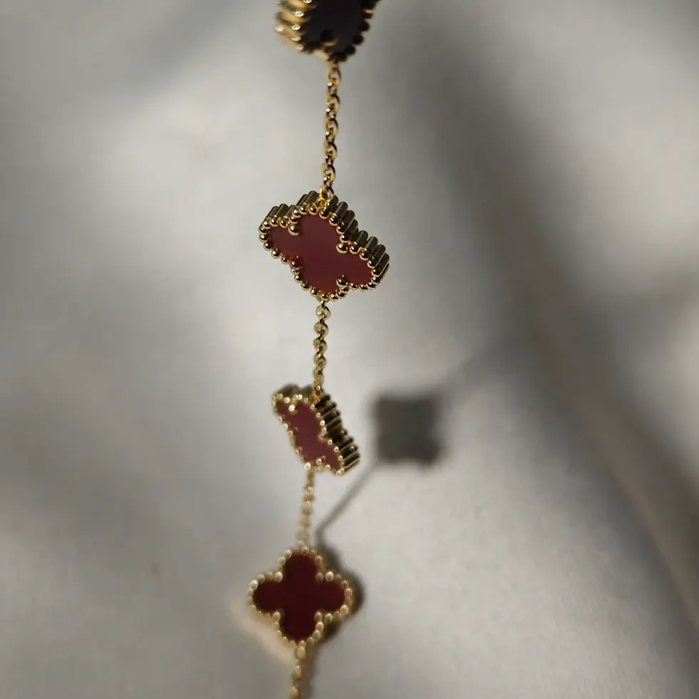 Minimal bracelet featuring a cherry red four-leaf clover charm