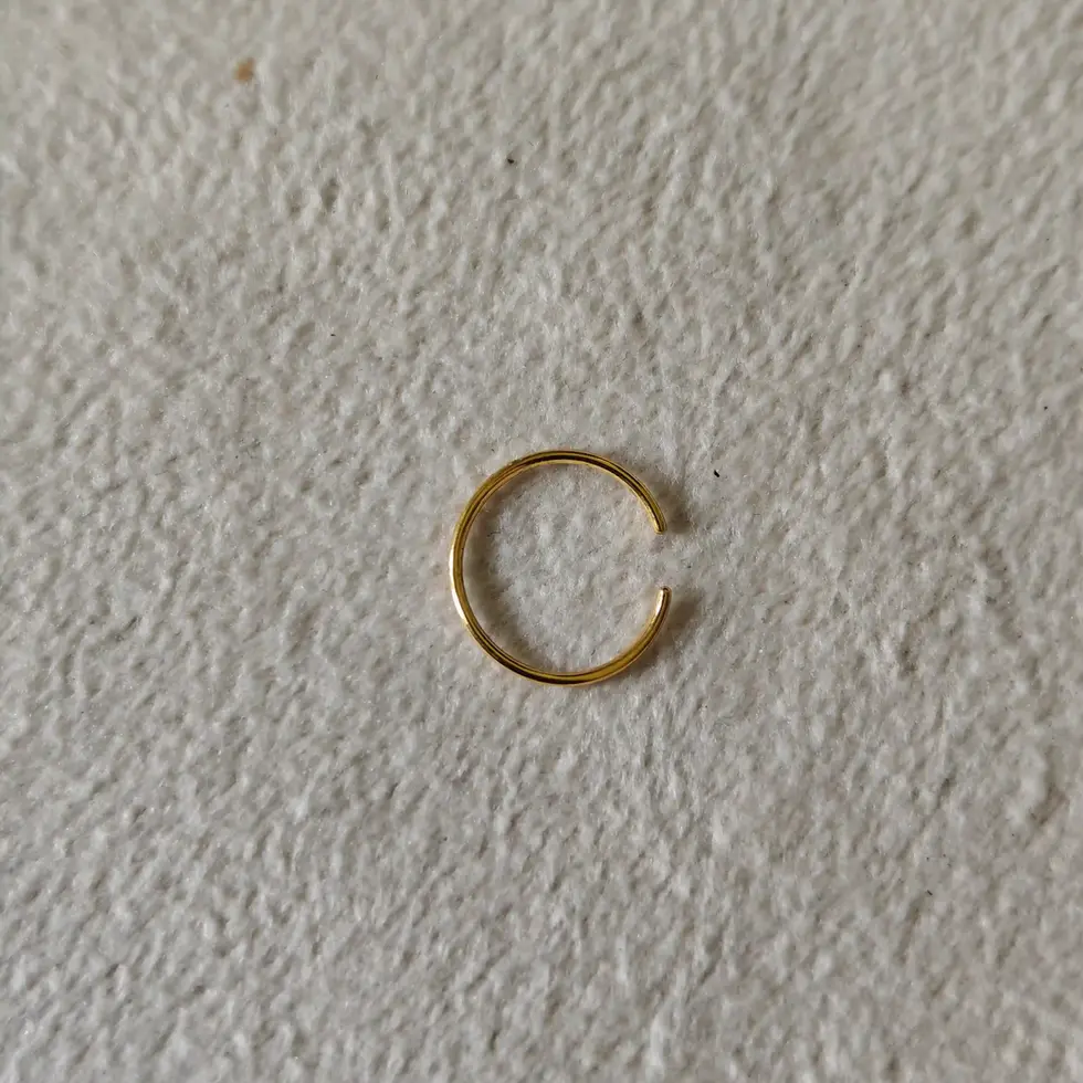 Large gold-tone non-piercing ring displayed on a neutral background. Minimal ear accessory designed for a bold everyday style