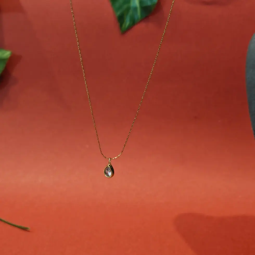 Gold-toned minimalist necklace with a small teardrop-shaped pendant on a fine chain.