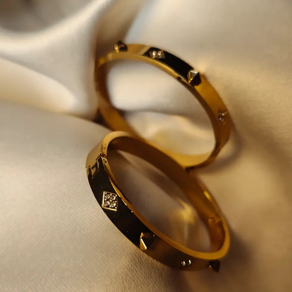 Thick gold bracelet featuring a triangle-shaped pyramid design in front and a plain gold back; designed for thin wrists (2.2–