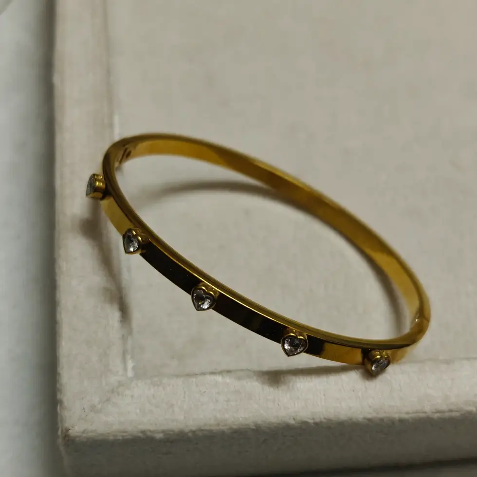 Gold-plated slim bangle bracelet with evenly spaced small crystal stone accents.