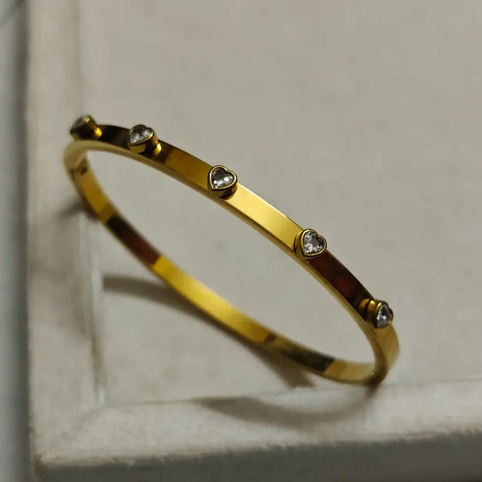 Gold-plated slim bangle bracelet with evenly spaced small crystal stone accents.