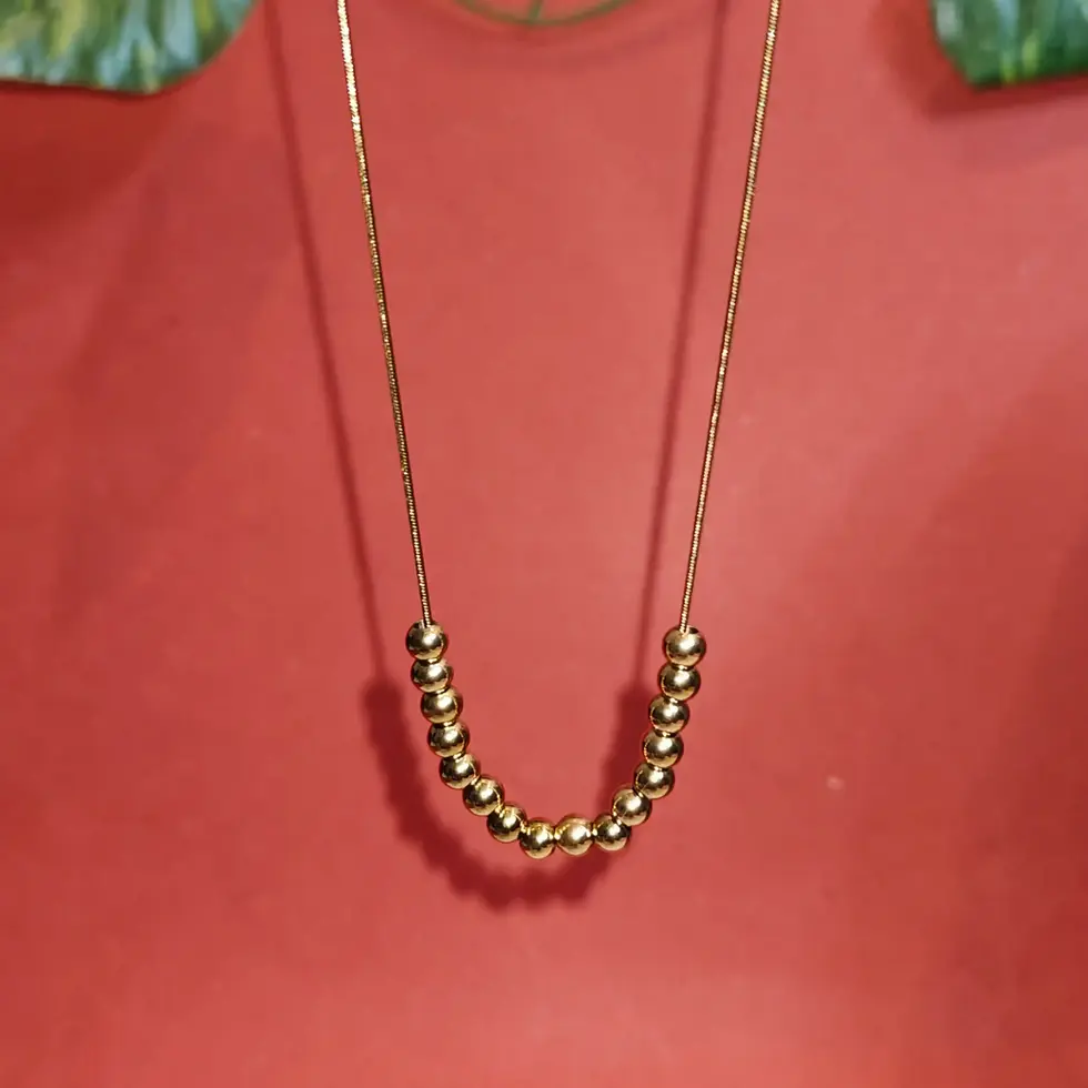 Elegant gold necklace featuring a curved arrangement of polished golden bead charms on a delicate chain.
