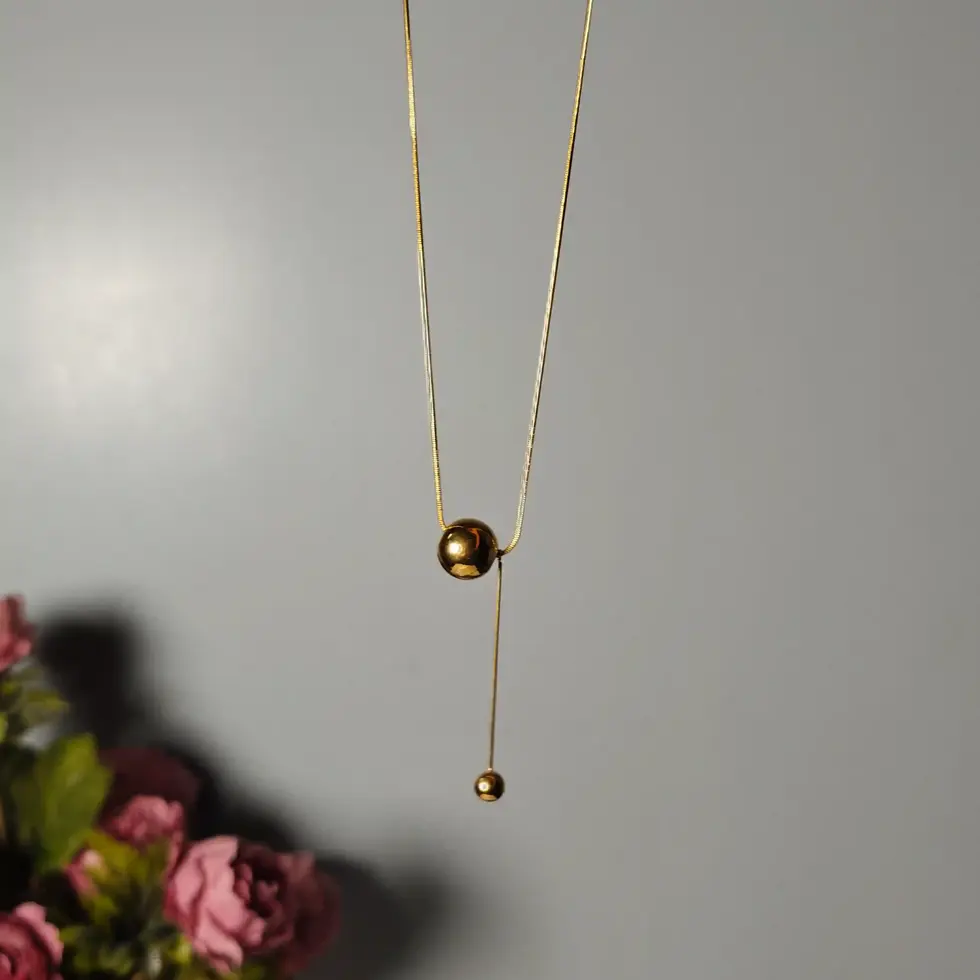 Gold-plated thin chain necklace with two ball pendants, one main and one hanging.