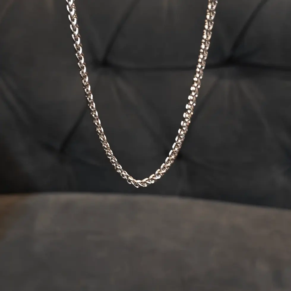 Long silver-tone men's twisted chain with an intricate woven design, offering a sleek and modern everyday look.