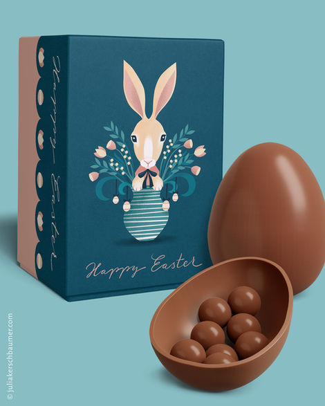 Easter gift wrap in dark blue on a light blue background featuring an illustration of a white Easter bunny peeking out of a vase of flowers; below it reads “Happy Easter” in blue and pink retro tones, with a chocolate egg and a half-egg filled with chocolate dragees.