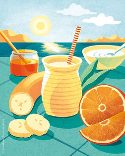 Arrangement of a glass of smoothie with a straw and ingredients like oranges, a cut banana, a glass of honey and a cup of yoghurt on a desk in front of the sunset over a sea coast, in yellow, orange and turquoise tones