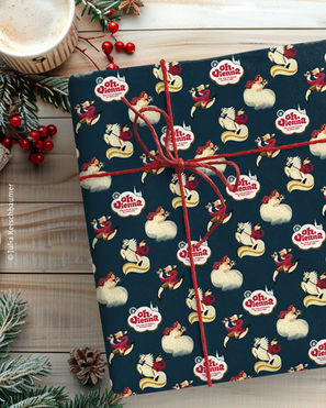 Package wrapped in paper with an illustrated pattern with Mozart, Kaiserin Sissi, a Lipizzaner horse and a hand lettering logo saying Oh Vienna on dark blue background on a winterly decorated white desk