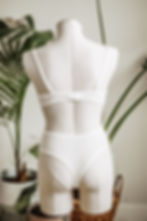 Thumbnail: White lingerie set on a mannequin, with leafy plants in the background.