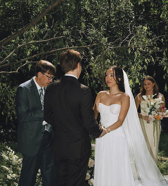 Romantic outdoor wedding portrait of Bride and groom standing together in nature.