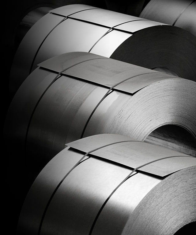 Steel coils in a dark surrounding.