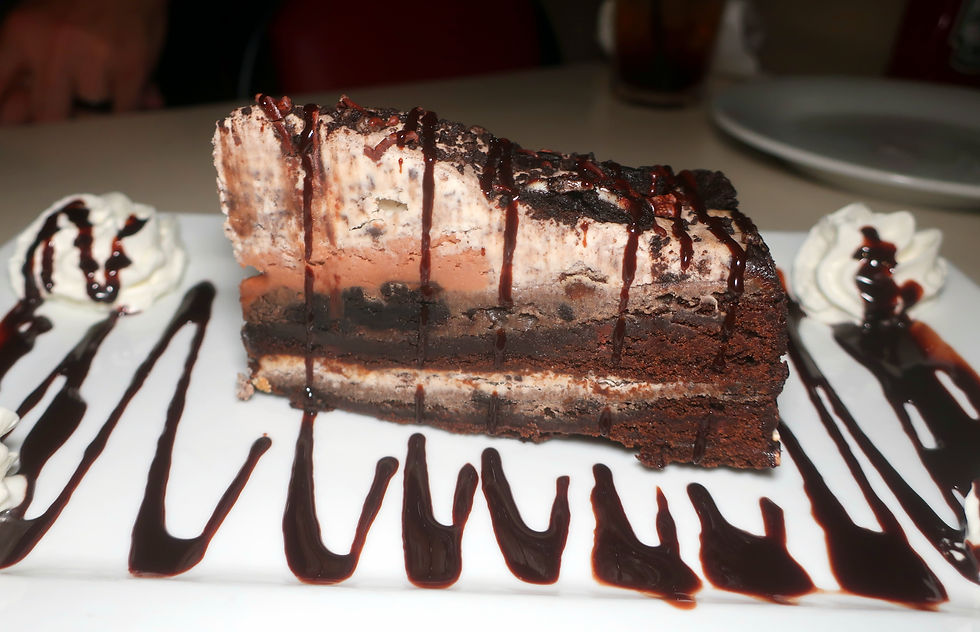 Two chewy brownie layers with cream cheese and broken OREO cookies. Topped with a center mound of milk chocolate ganache, covered with cookie mousse, and edged with chocolate fudge. To finish, it's sprinkled with more OREO and chocolate drizzle.