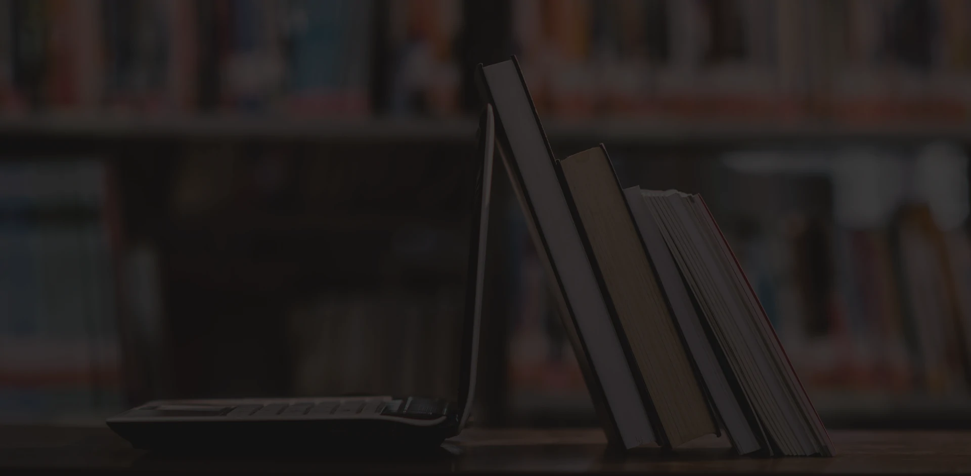 laptop-computer-and-book-on-workplace-in-library-room.webp