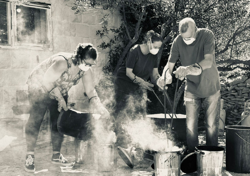 raku firing, with pots coming out of the kiln and being covered with sawdust