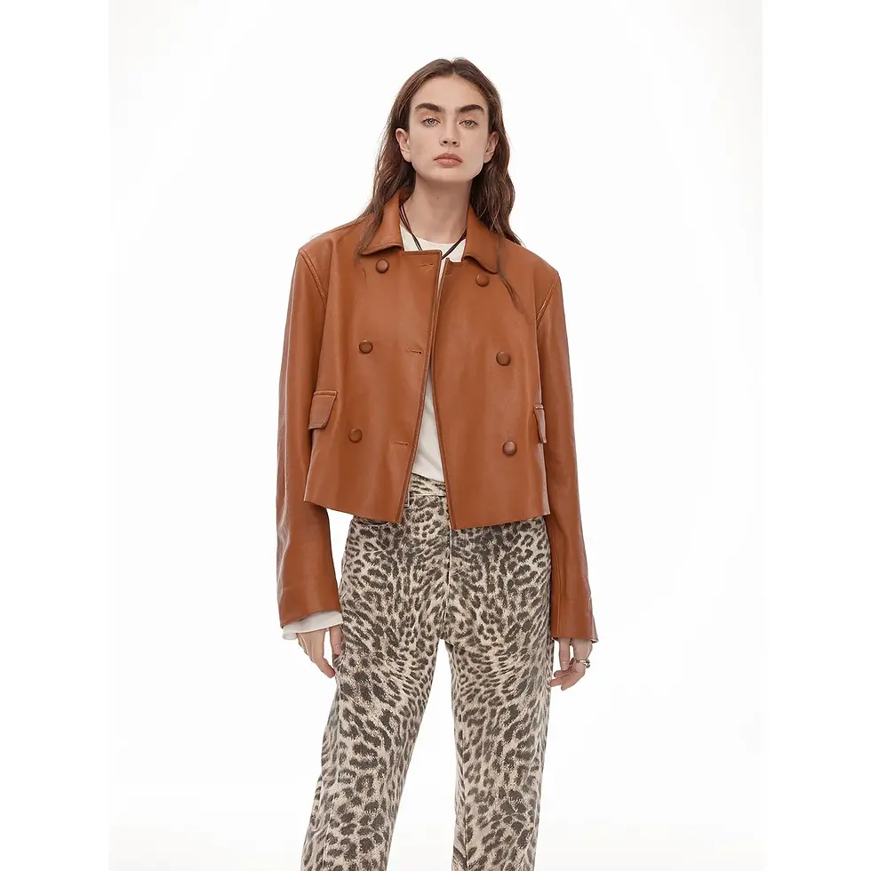 Woman in a brown leather jacket and leopard print pants stands against a white background, displaying a neutral expression.