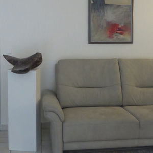 Abstrakte Steinskulptur auf weißem Sockel