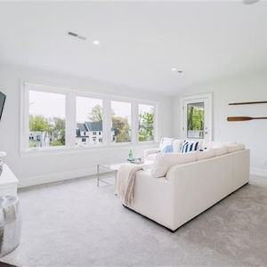 a 3rd floor living room with a white couch , table , and television.