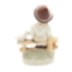 Little Boy Sitting on Wooden Fence with Bird Figurine