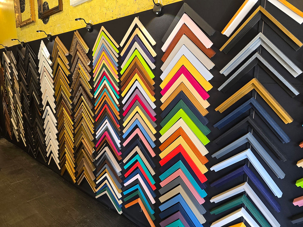 Numerous colorful picture frame samples on a wall display