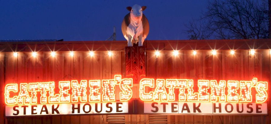 neon lights of Cattlemen's Steak House's famous marquee with a cow statue on top