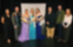 A group photo with the three winning titleholders and the competition judges who chose them. They are all standing in a line together and smiling.