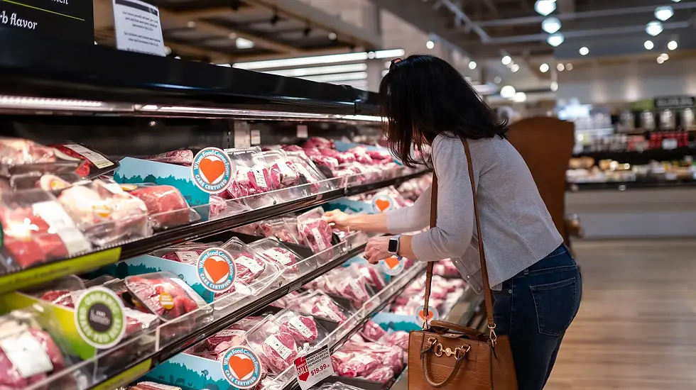 Woman shopping in the meat aisle at Heinen's