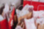 Gift bags in red and brown with white tissue paper, adorned with snowflake tags and red patterns, create a festive atmosphere.