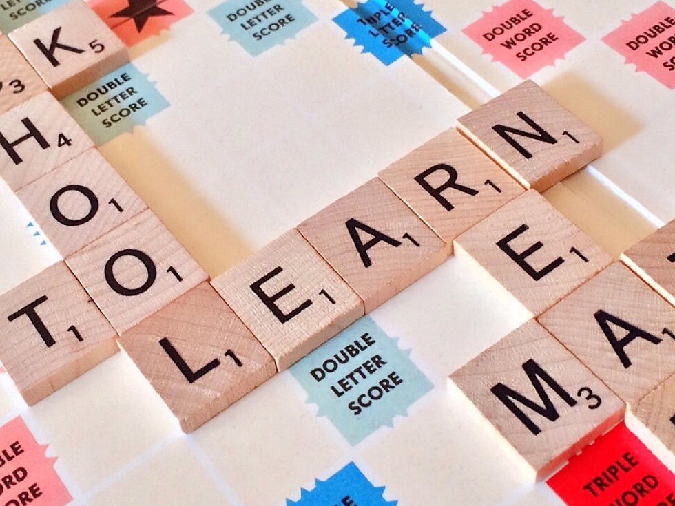 Scrabble board with wooden tiles spelling "LEARN." Bright squares show "Double Letter Score" and "Double Word Score."