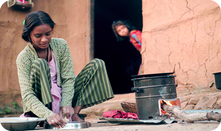 Eine junge Frau bereitet traditionelles Brot auf einem verbesserten Kochofen zu.