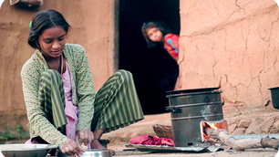 Eine junge Frau bereitet traditionelles Brot auf einem verbesserten Kochofen zu.