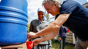 First Climate CEO und eine Schülerin beim Wasserzapfen in Kenia