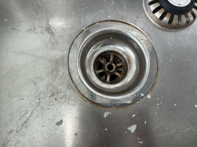 Before cleaning - dirty stainless steel sink with stains and marks.