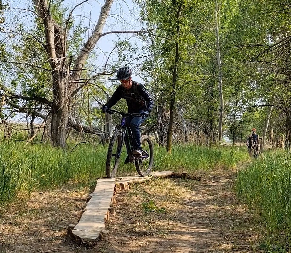 A mountain biker navigating the beginner skinny feature on the Blackstrap trails