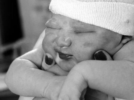 Newborn baby being held up