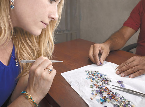 Client and Sri Lankan gem expert reviewing a curated selection of natural sapphires together, examining stones by hand during the selection process.