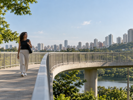 Adulto atravessa uma passarela contemporânea em área urbana arborizada, com a estrutura do caminho e trabalhadores de manutenção discretamente visíveis ao fundo.
