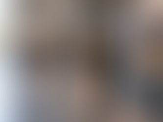 Adulto em uma exposição histórica contemporânea, observando atentamente fotografias e objetos de memória em um espaço público amplo e sóbrio.