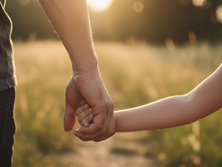 Mão de adulto segurando com firmeza a mão de uma criança, simbolizando a força de Deus que se aperfeiçoa na fraqueza e na rendição humana.