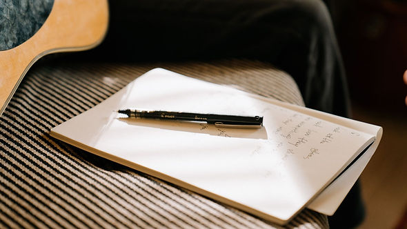 songbook on couch next to close up of guitar player.jpg