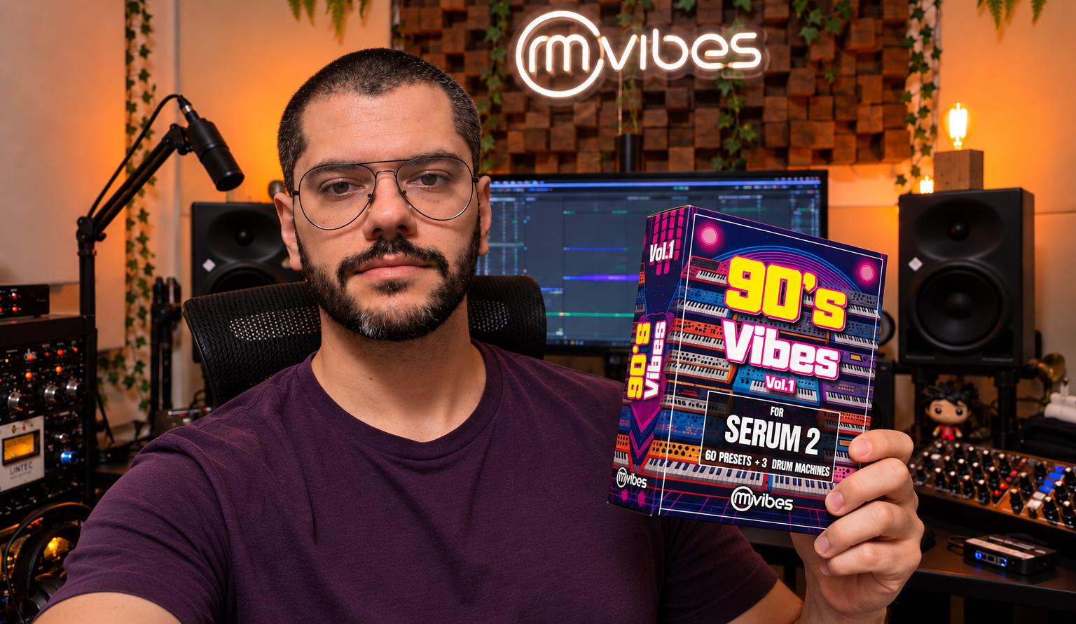 Rafael Manga holding the 90's Vibes Serum 2 preset pack in his music studio